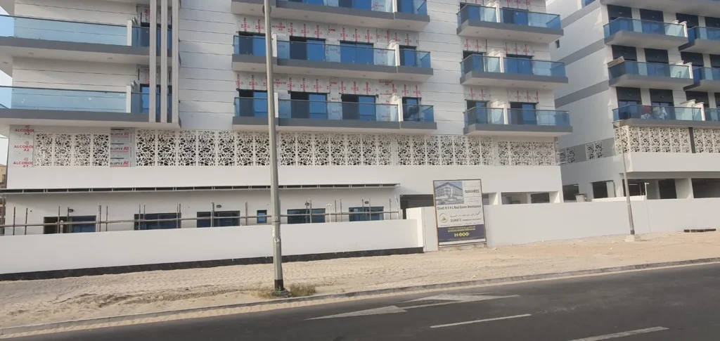 Perforated ACP panels and glass balcony railings on an apartment building